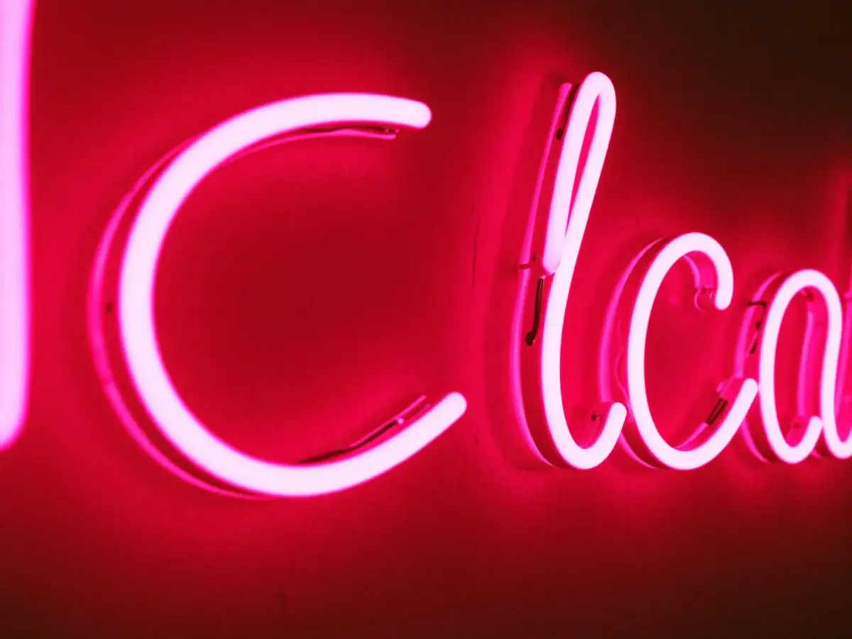 Neonletters in warme kleur boven de bar van een café in Antwerpen